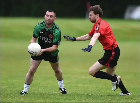  ??  ?? Dara O’Shea, Churchill hand passes the ball ahead of Shane Malone, Fossa in the Kerry County Credit Union league at Fossa on Saturday. Photo by Michelle Cooper Galvin