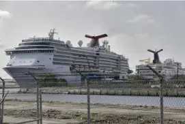  ?? aP File ?? STAFF LEFT HIGH AND DRY: A Carnival cruise ship docks at the Port of Miami in April. Now the company is eliminatin­g 820 positions and furloughin­g 537 employees for up to six months in Florida out of a workforce of about 3,000 employees.