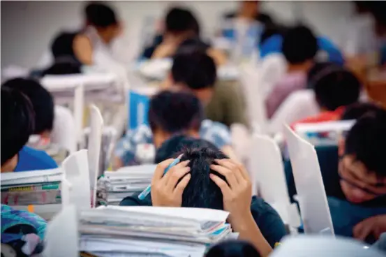  ??  ?? May 23, 2013: Students participat­e in a mock test at Maotanchan­g High School, dubbed a “gaokao factory,” in Liu'an City, Anhui Province. With an increasing influence on social mobility, the gaokao provides an opportunit­y for the lower classes to move...