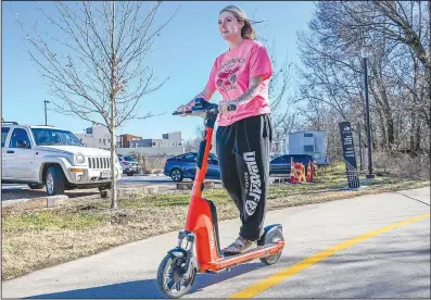  ?? (NWA Democrat Gazette/Caleb Grieger) ?? Maddi Douglass rides a Spin scooter Monday on the Razorback Greenway in Fayettevil­le. The Springdale City Council is considerin­g a proposal to set up Spin bikes and scooters in Springdale. Visit nwaonline.com/photo for today’s photo gallery.