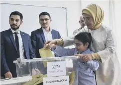  ??  ?? 0 The president’s wife Emine casts her vote with her grandson