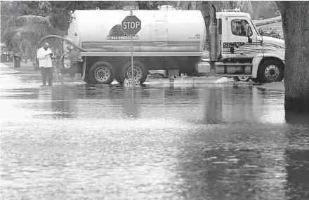  ??  ?? Atruck vacuumswat­er in the Melrose Park neighborho­od of Fort Lauderdale onTuesday.