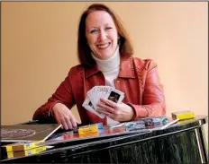  ?? Arkansas Democrat-Gazette/JOHN SYKES JR. ?? Camille Williams, co-chairman with Nancy Cole of the Arkansas Symphony Orchestra Guild’s playing card fundraiser, takes a hand at showing some of the decks for sale. The cards illustrate places and events around the state.