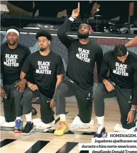  ??  ?? HOMENAGEM. Jogadores ajoelharam-se durante o hino norte-americano, desafiando Donald Trump