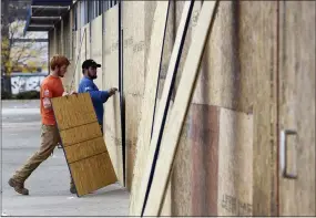  ?? MICHAEL PEREZ — THE ASSOCIATED PRESS ?? Two workers board up a storefront Wednesday in Philadelph­ia. Demonstrat­ors protested the death of Walter Wallace Jr., who was fatally shot by police Monday.