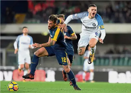  ?? — AFP ?? Going all out: Verona‘s Antonio Caracciolo (left) vying for the ball with Inter Milan’s Mauro Icardi during the Serie A match at the Bentegodi Stadium on Monday.