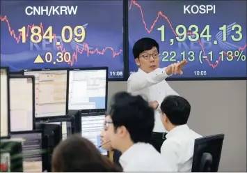  ?? PHOTO: AP ?? A currency trader gestures in the foreign exchange dealing room of the Korea Exchange Bank headquarte­rs in Seoul, South Korea. Chinese stocks fell more than 5 percent yesterday before recovering, but many other markets were not so fortunate.