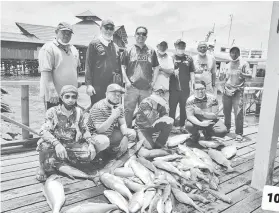  ??  ?? ALBUM KENANGAN: Penulis bersama semua pemancing bergambar di Jeti Kudat.