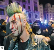  ?? PHOTOS AFP ?? 1. 350 000 personnes se sont rassemblée­s hier à Barcelone. 2. Des policiers marchent à côté d’une barricade en flammes. 3. Un manifestan­t saigne après avoir été frappé par un agent de la paix.