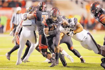  ?? RICK BOWMER/ASSOCIATED PRESS ?? Utah running back Zack Moss (2) breaks free from California nose tackle Luc Bequette on Saturday. Utah, thought to be a playoff prospect from the Pac-12, plays this weekend at Washington.