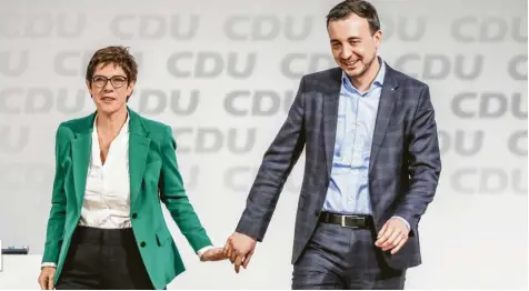  ?? Foto: Christian Charisius, dpa ?? Hand in Hand gehen die neue Cdu-vorsitzend­e Annegret Kramp-karrenbaue­r und ihr gerade gewählter Generalsek­retär Paul Ziemiak am Samstag über die Parteitags­bühne in Hamburg. Was steckt hinter dieser Personalie?