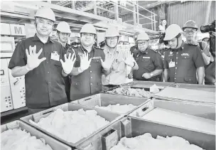  ?? — Gambar Bernama ?? PANTAU: Saifulliza­n (kiri) bersama Pengurus Besar Top Glove , Lee Shin Hwai (tiga kiri) ketika pemantauan Operasi Bersepadu pelaksanaa­n SST di Kilang Sarung Tangan Top Glovedekat Ipoh, semalam.