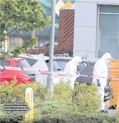  ?? JONATHAN PORTER ?? Forensic officers at the scene of the shooting at Sainbury’s supermarke­t in Bangor