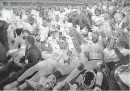  ?? PHELAN M. EBENHACK/ORLANDO SENTINEL ?? Bethune-Cookman head coach Terry Sims, center, poses with his players after earning a 33-19 win over Florida A&amp;M in the Florida Classic Saturday at Camping World Stadium.