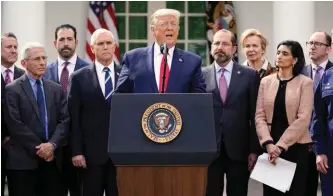  ?? AP PHOTO/EVAN VUCCI ?? President Donald Trump, surrounded by the federal COVID-19 team, addresses the media on March 13 to discuss the screening site from Verily, a sister company of Google.