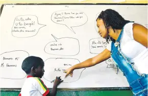  ?? JESÚS RICO ?? La profesora Delia Cabarcas le enseña a John Alex algunas palabras en lengua palenquera, en el Centro etnoeducat­ivo Paulino Salgado Batata.