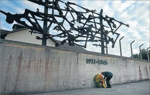  ?? JOERG KOCH / GETTY ?? La cancillera haciendo entrega de una corona de flores a las puertas del campo de concentrac­ión de Dachau