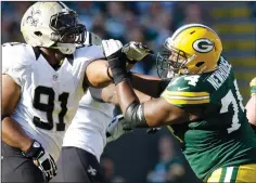  ?? JOHN KLEIN/TRIBUNE NEWS SERVICE ?? Marshall Newhouse, right, battles Saints defensive end Will Smith in 2012 at Lambeau Field in Green Bay.