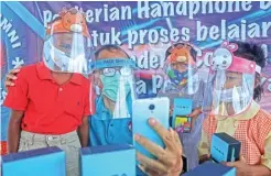  ?? RIANA SETIAWAN/JAWA POS ?? KEBUTUHAN PRIORITAS: Ketua Ikasatya Surabaya Yonatan Rudyanto (dua dari kiri) bersama siswa-siswa Sekolah Pelita Permai penerima bantuan ponsel Sabtu (1/8).