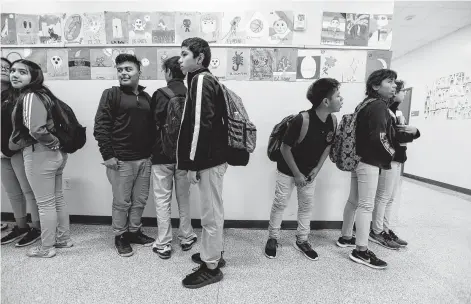  ?? Steve Gonzales / Staff photograph­er ?? Students wait in the hallway between classes at Pilgrim Academy, where many students come from low-income and immigrant families.