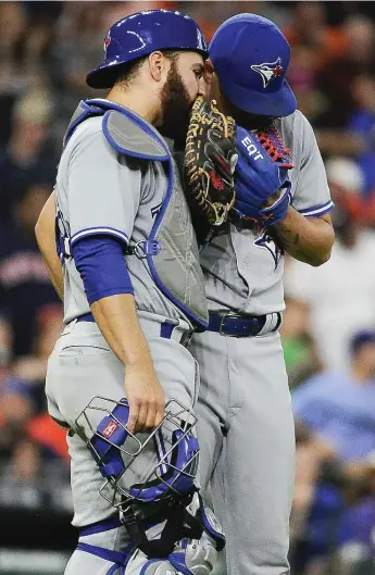  ?? ERIC CHRISTIAN SMITH/THE ASSOCIATED PRESS ?? Jays catcher Russell Martin talks it over with closer Roberto Osuna, dinged for four runs on five hits in the ninth.