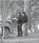  ?? NIKKI BOERTMAN/AP ?? Police investigat­e the scene of multiple shootings Friday in Arkabutla, Miss. The Tate County sheriff says a man is in custody in connection to the shootings, which left six people dead.