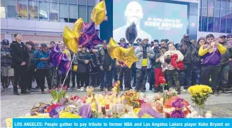  ??  ?? LOS ANGELES: People gather to pay tribute to former NBA and Los Angeles Lakers player Kobe Bryant on January 26, 2020 following his death in a helicopter crash near Los Angeles. — AFP