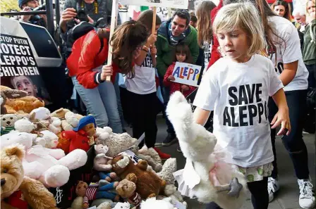  ??  ?? Rallying for peace: A child placing a stuffed toy at the gates of Downing Street during a demonstrat­ion urging the British government to intervene in the bombing of Aleppo in London. — Reuters