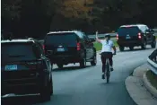  ?? — AFP ?? A woman on a bike gestures with her middle finger as a motorcade with US President Donald Trump departs Trump National Golf Course in Sterling, Virginia.