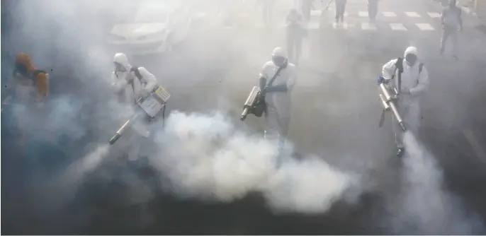  ?? AFP via Gett y Images ?? Iranian firefighte­rs disinfect streets in the capital Tehran on Friday in a bid to halt the wild spread of coronaviru­s. Iranian forces were clearing the streets nationwide in a 24-hour period and all citizens were to be checked for the new coronaviru­s in a bid to halt its spread, the military said.