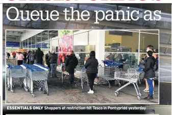  ??  ?? ESSENTIALS ONLY Shoppers at restrictio­n-hit Tesco in Pontypridd yesterday