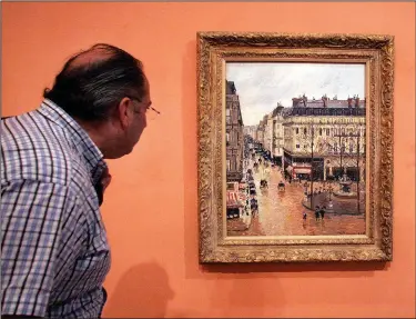  ?? (File Photo/AP/Mariana Eliano) ?? A museum visitor views “Rue Saint-Honoré in the Afternoon, Effect of Rain,” on May 12, 2005, in the museum.