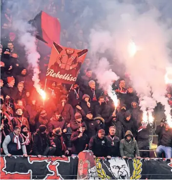  ??  ?? Leverkusen­er Fans zünden am Sonntag beim Spiel in Köln Pyrotechni­k.