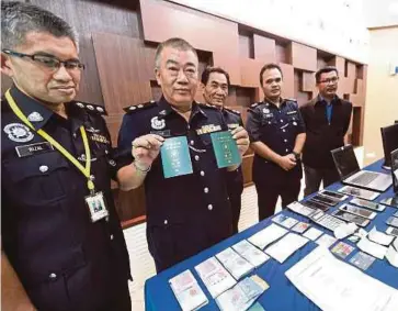  ?? BERNAMA PIC ?? Kedah Commercial Crime Investigat­ion Department chief Superinten­dent Chan Teck Paing (second from left) showing passports belonging to the Taiwanese suspects and items seized from the syndicate at the state police contingent headquarte­rs in Alor Star...
