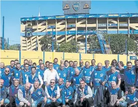  ??  ?? Enojados. Empleados de Utedyc posan con la Bombonera de fondo.