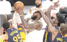  ?? AP PHOTO ?? LA Lakers forward LeBron James (center) is fouled by Golden State Warriors guard Kelly Oubre Jr. (right) during the first half of an NBA basketball game on Feb. 28, 2021 (March 1 in Manila) in Los Angeles.