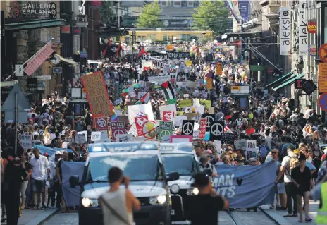  ?? Reuters; AP ?? A large crowd protest ahead of the meeting between Donald Trump and Vladimir Putin in Helsinki. Left, Mr Trump boards Air Force One on his way from Scotland to Finland