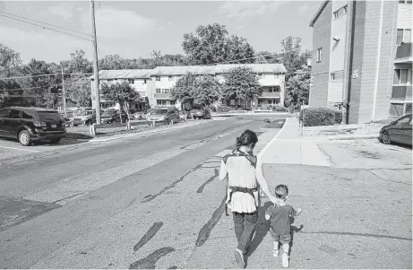  ?? Matt McClain photos / Washington Post ?? Lisa So carries her son, Felix, 9 months, while walking with her other son, Xavier, 2, at Parkview Gardens Apartments.