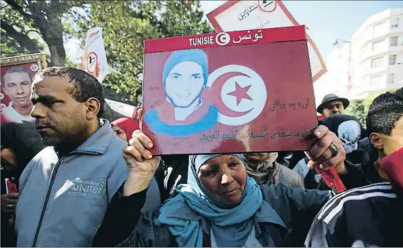  ?? MOHAMED MESSARA / EFE ?? Una mujer muestra la foto de un familiar muerto en la revolución tunecina del 2011, en la avenida Habib Bourguiba de Túnez