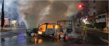  ?? — AFP photo ?? A firefighte­r puts out a car fire after alleged alleged students of the ‘Isidro Burgos’ Normal Rural School of Ayotzinapa stole and set the pick-up truck in flames, in Chilpancin­go, State of Guerrero, Mexico.