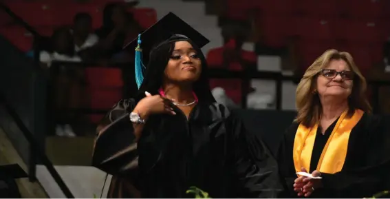  ?? ?? A SEARK graduate tries to hold back tears before receiving her degree as administra­tive assistant Jenny McVay helps with the graduation. (Pine Bluff Commercial/I.C. Murrell)