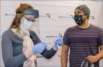  ?? Courtesy photo / Adventist Health Sonora ?? Brandi Axtell, a registered nurse at Adventist Health Sonora, prepares to give the COVID-19 vaccine to Dr. Joseph Protacio.