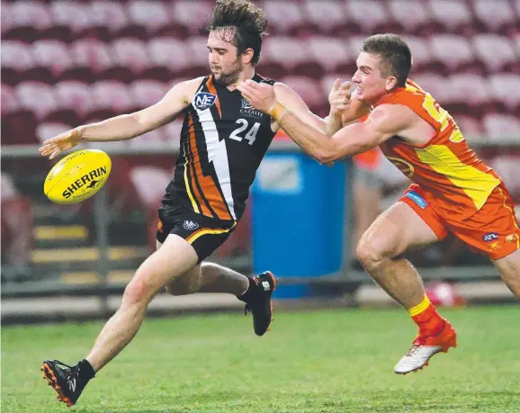  ?? Picture: JUSTIN KENNEDY ?? NT Thunder’s Abraham Ankers gets a kick away last night at TIO Stadium as Gold Coast Suns opponent Charlton Offermans closes in