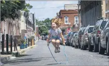  ?? JOSE F. MORENO — THE PHILADELPH­IA INQUIRER VIA AP ?? Julienna Putnick, 7, jumps rope in the middle of the street on the 2500 block of South Marshall Street in South Philadelph­ia, Pa. Wednesday. The street is closed to traffic as part of the Playstreet­s program in the City of Philadelph­ia.