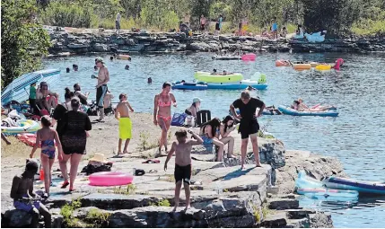  ?? DAVE JOHNSON TORSTAR ?? The former quarry at the south end of Wainfleet Wetlands Conservati­on Area, on Quarry Road, is packed with people looking to beat the heat Saturday afternoon.