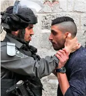  ?? — AFP ?? Palestinia­n President Mahmud Abbas ( left) with French President Emmanuel Macron during a joint conference in Paris on Friday. An Israeli borderguar­d ( right) argues with a Palestinia­n man in Jerusalem on Friday.