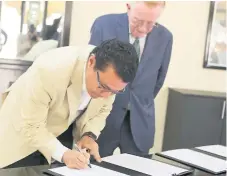  ??  ?? OFICIAL. Donald Eugene Panoz observa cuando Ebal Díaz firma el convenio de entendimie­nto para oficializa­r la inversión.