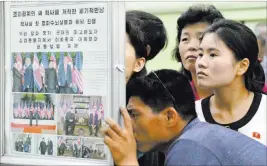  ?? Minoru Iwasaki ?? The Associated Press People look at a newspaper display Wednesday in Pyongyang, North Korea, reporting the meeting between North Korean leader Kim Jong Un and President Donald Trump.