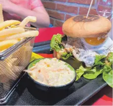  ?? FOTO: NYF ?? Üppige Portionen: Burger mit Soße, Speckstrei­fen und Spiegelei, dazu Pommes frites und Salat.
