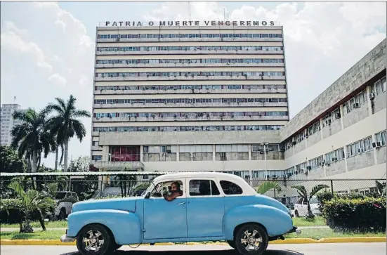  ?? ALEXANDRE MENEGHINI / REUTERS ?? Iconos. Un viejo auto de los que todavía circulan milagrosam­ente pasa frente a un edificio de la Habana coronado en la azotea, como otros muchos en la isla, con la proclama “Patria o muerte, venceremos”